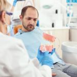 dentist explaining denture care to a patient